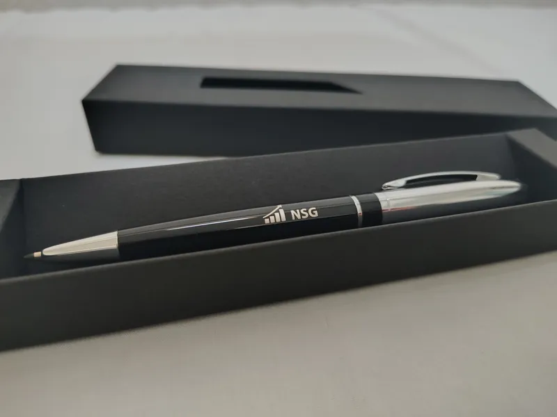 Bolígrafo metálico grabado con el logo de NSG dentro de su estuche negro