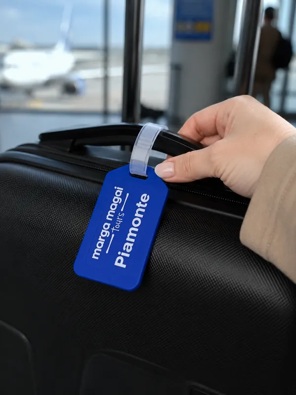 Tag de equipaje azul con el logo de Piamonte colgado de una valija
